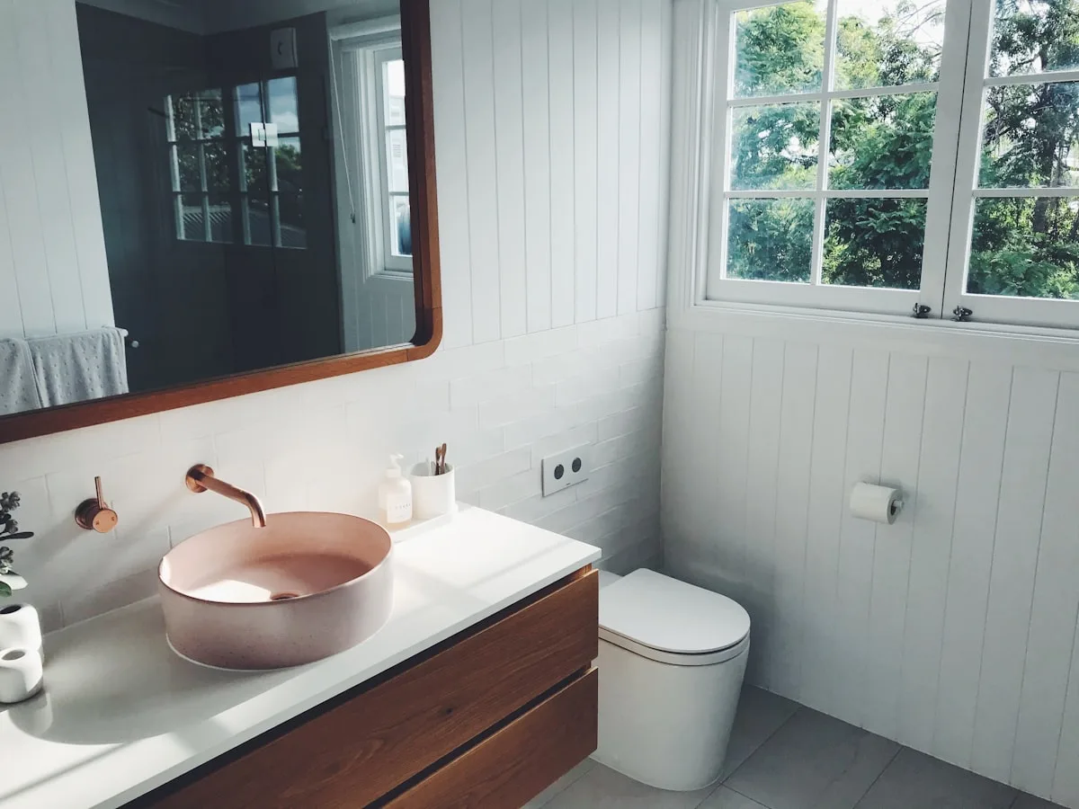 Bright, calm bathroom with a soft-toned basin, white walls, and natural light